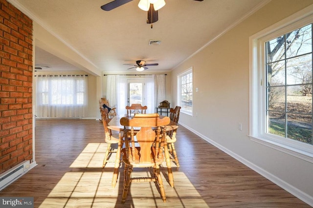 dining area with crown molding, ceiling fan, a baseboard heating unit, and hardwood / wood-style flooring