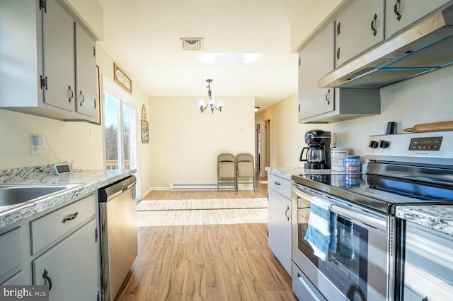 kitchen with appliances with stainless steel finishes, light hardwood / wood-style flooring, a notable chandelier, gray cabinets, and hanging light fixtures