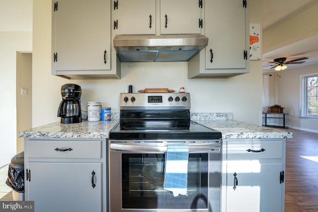 kitchen featuring stainless steel range with electric stovetop, ventilation hood, dark hardwood / wood-style floors, ceiling fan, and light stone counters