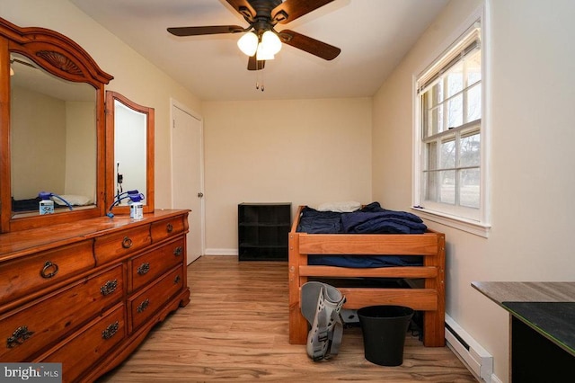 bedroom with a baseboard radiator, light hardwood / wood-style flooring, and ceiling fan