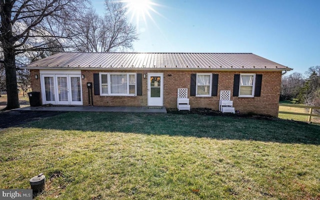 ranch-style home with french doors and a front lawn