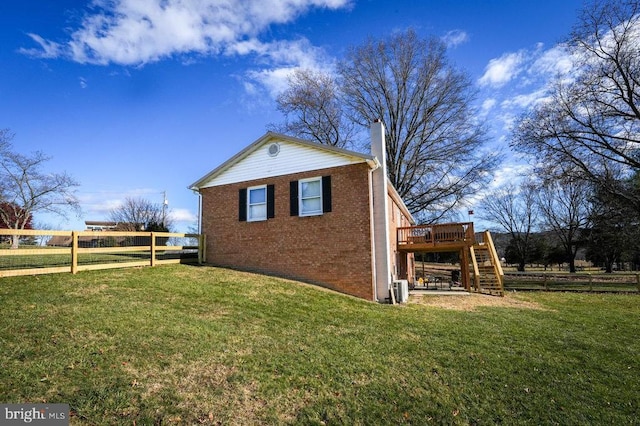 view of side of home featuring a lawn and a wooden deck