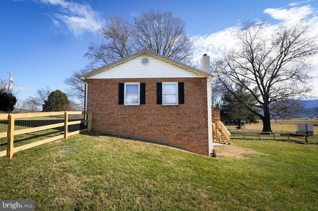 view of side of home with a yard