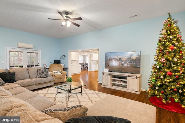 living room with french doors, ceiling fan, hardwood / wood-style floors, and a wall mounted air conditioner