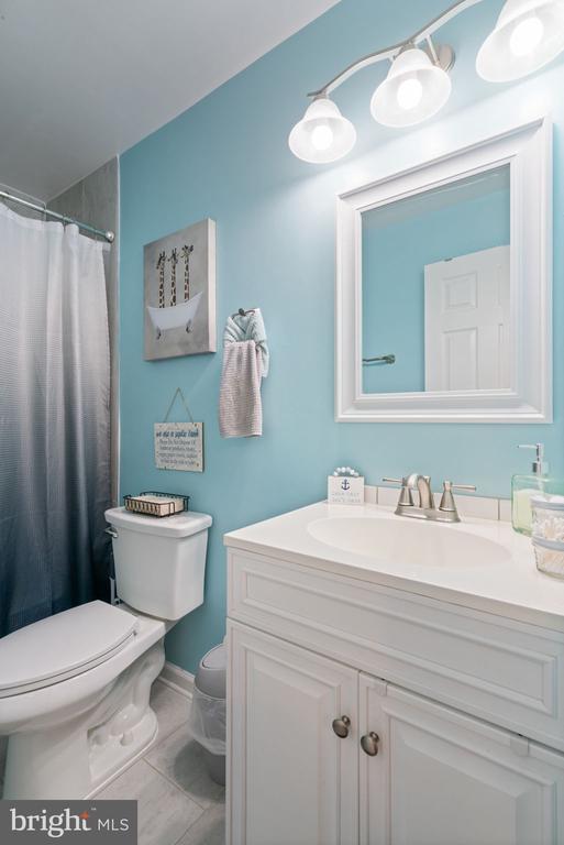 bathroom with tile patterned flooring, a shower with curtain, vanity, and toilet