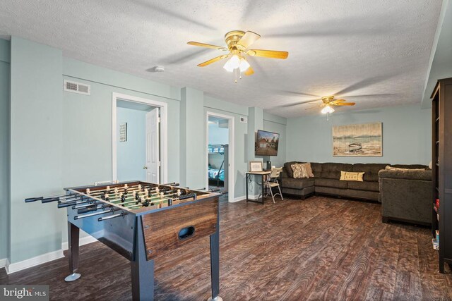 game room featuring ceiling fan, a textured ceiling, and dark wood-type flooring