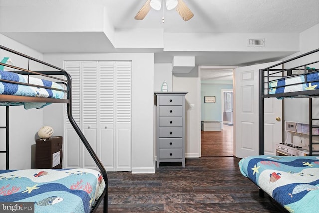 bedroom with a closet, dark wood-type flooring, and ceiling fan