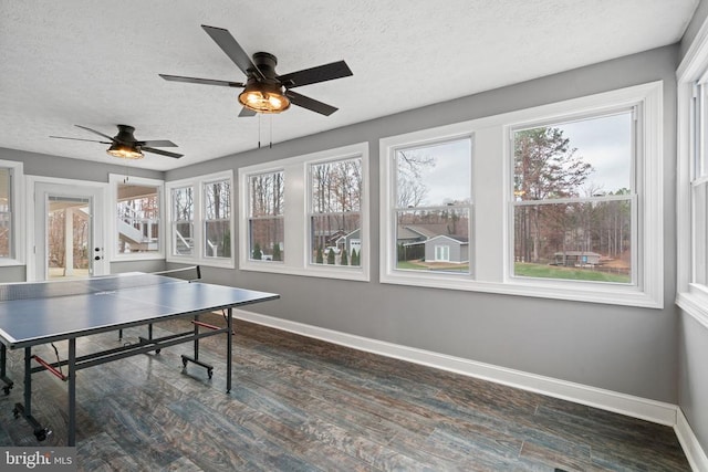 rec room with ceiling fan, dark hardwood / wood-style flooring, and a textured ceiling