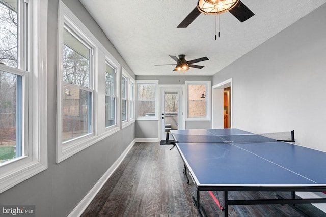 playroom featuring ceiling fan, dark wood-type flooring, a healthy amount of sunlight, and a textured ceiling