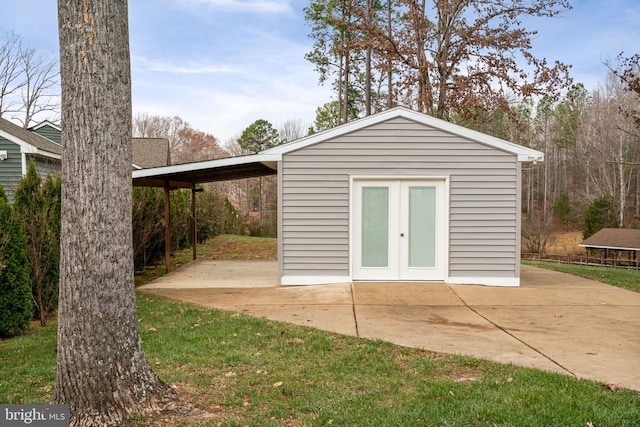 view of outdoor structure with a carport and a lawn