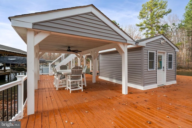 wooden terrace with ceiling fan and a water view