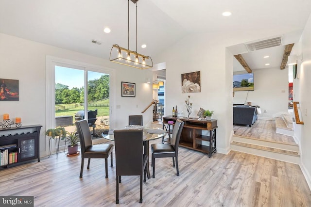 dining space featuring light hardwood / wood-style flooring and vaulted ceiling