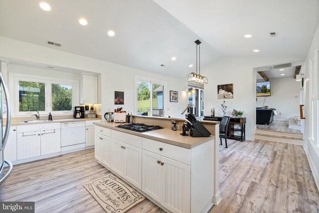 kitchen with white dishwasher, white cabinets, light hardwood / wood-style flooring, vaulted ceiling, and a kitchen island