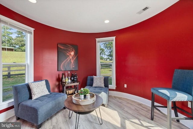 sitting room with plenty of natural light and wood-type flooring