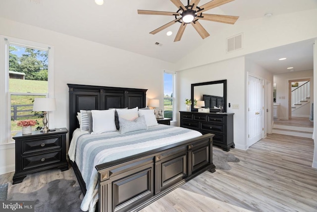 bedroom featuring ceiling fan, lofted ceiling, and light wood-type flooring