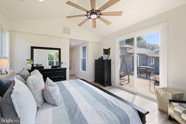 bedroom featuring access to exterior, light wood-type flooring, lofted ceiling, and multiple windows