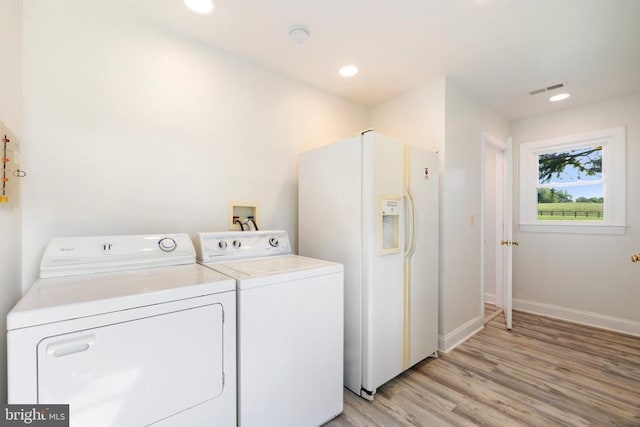 clothes washing area featuring light hardwood / wood-style floors and washing machine and clothes dryer