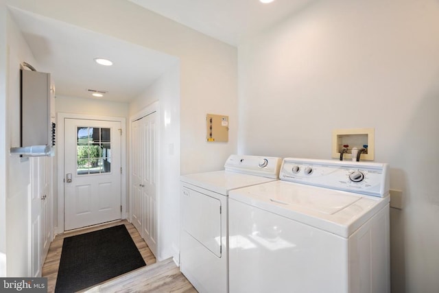 laundry room featuring light wood-type flooring and washing machine and clothes dryer