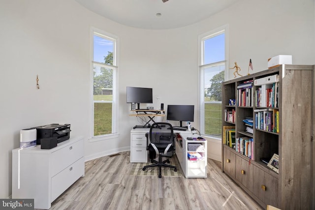 home office with light wood-type flooring and plenty of natural light