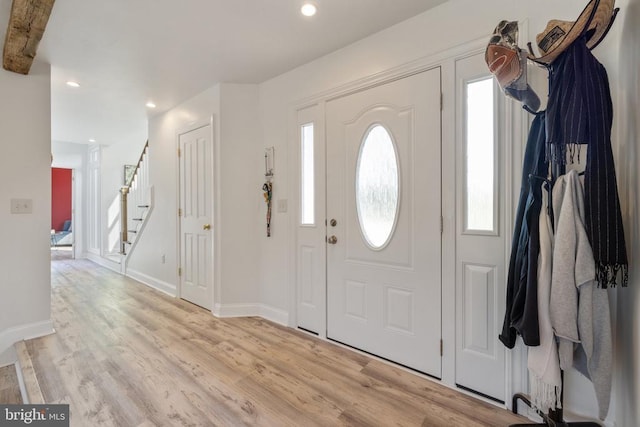 entrance foyer with beamed ceiling and light hardwood / wood-style floors