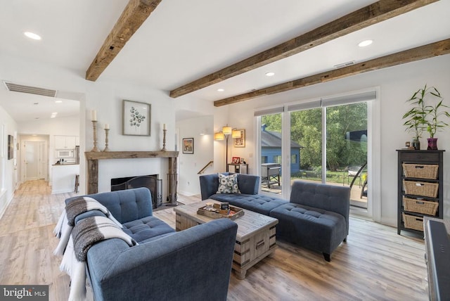 living room with beamed ceiling and light hardwood / wood-style floors