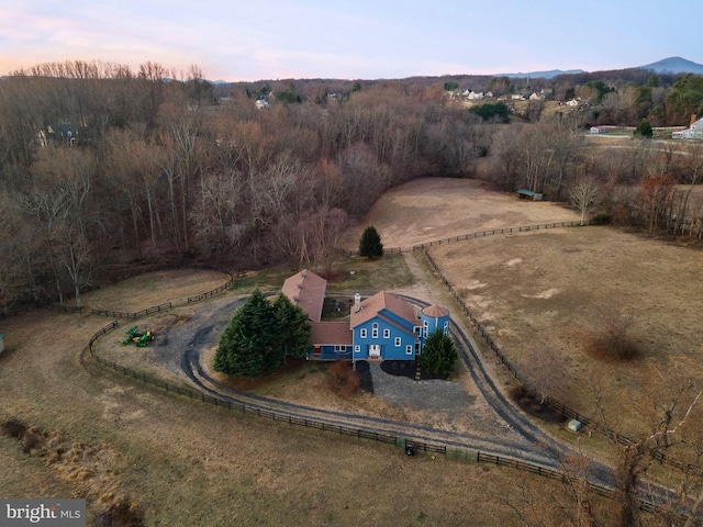 aerial view at dusk featuring a mountain view and a rural view