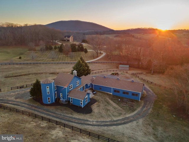 aerial view at dusk with a mountain view and a rural view