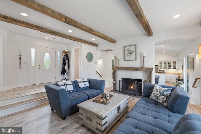 living room with light hardwood / wood-style flooring and lofted ceiling with beams