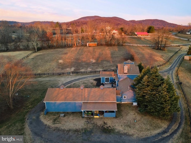 aerial view at dusk with a mountain view and a rural view