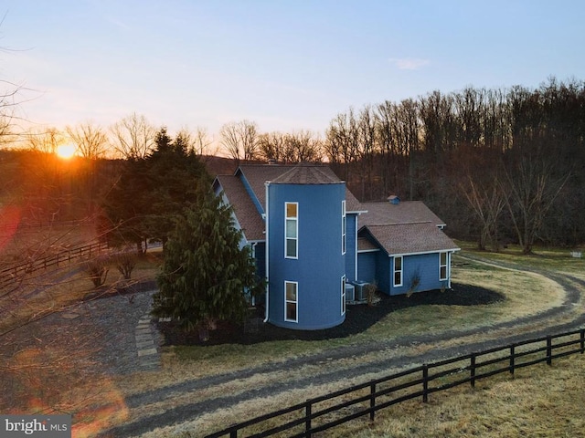 property exterior at dusk with a lawn