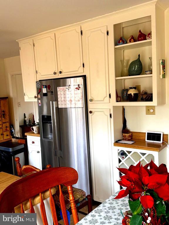 kitchen featuring white cabinetry and stainless steel fridge with ice dispenser