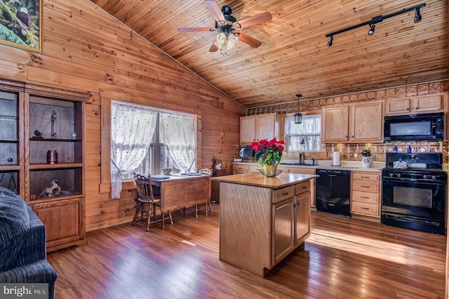 kitchen featuring wood walls, dark wood-type flooring, a kitchen island, and black appliances