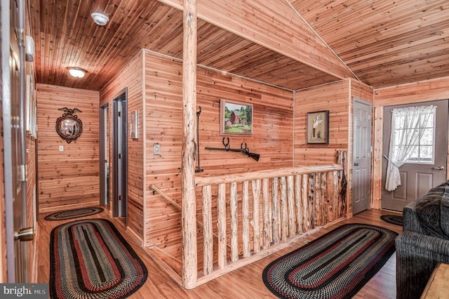 interior space featuring wood walls, lofted ceiling, and hardwood / wood-style flooring