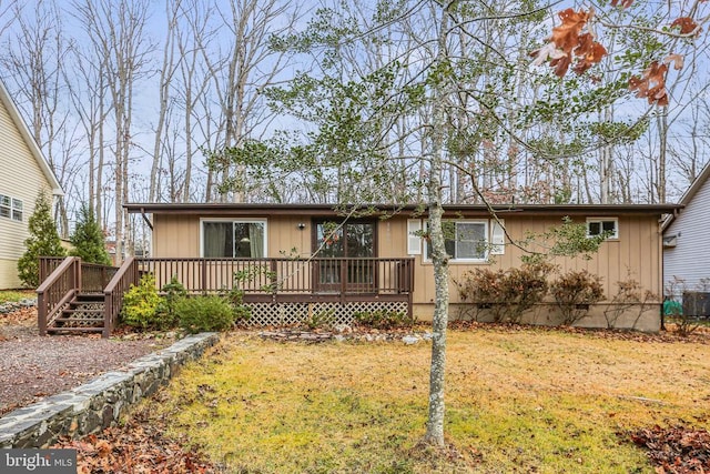 view of front of home featuring a front lawn and a wooden deck