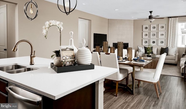 kitchen with sink, dark brown cabinets, stainless steel dishwasher, pendant lighting, and hardwood / wood-style floors