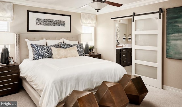 carpeted bedroom with ornamental molding, a barn door, and connected bathroom