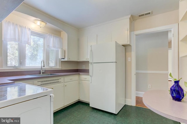 kitchen with white fridge, sink, ornamental molding, and white cabinetry