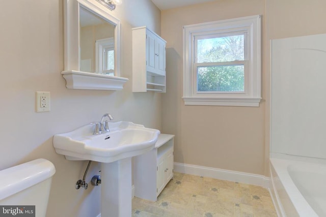 bathroom with toilet and a tub