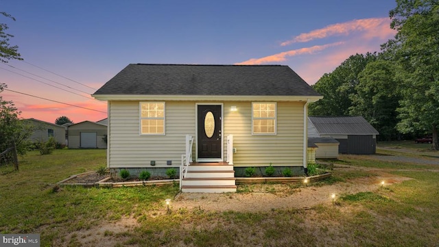 bungalow-style home featuring an outbuilding and a yard