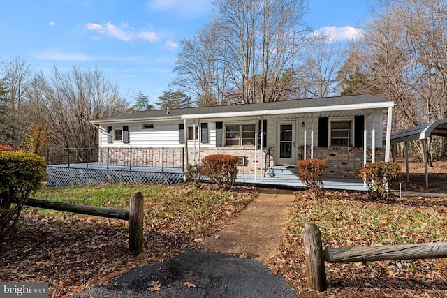 ranch-style home featuring covered porch and a carport