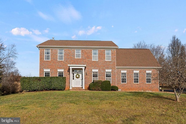 colonial inspired home with a front lawn