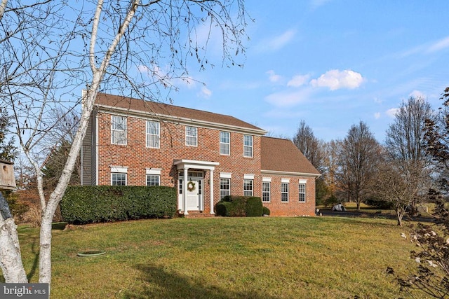 colonial inspired home featuring a front lawn