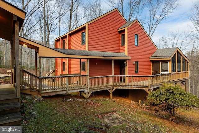 back of property featuring a wooden deck and a sunroom