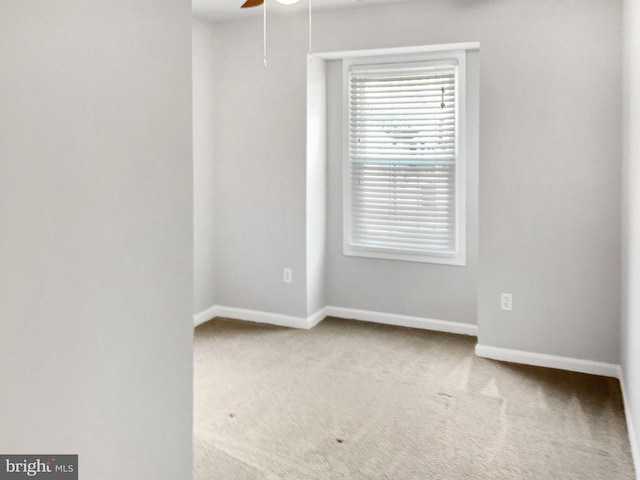 carpeted spare room featuring ceiling fan