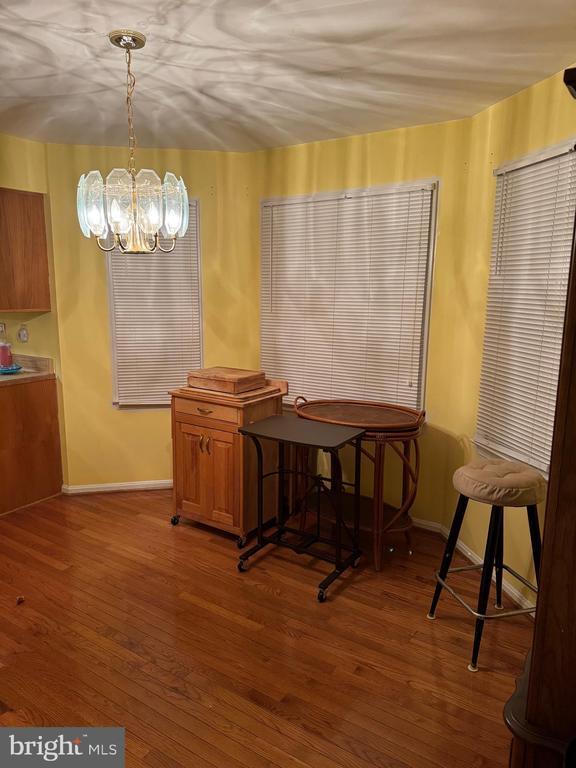 dining area featuring hardwood / wood-style floors and a notable chandelier