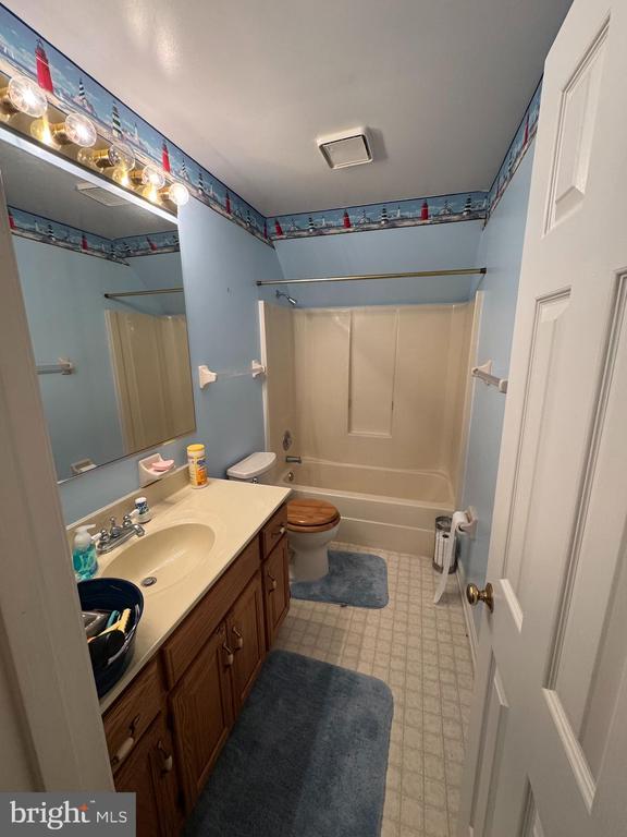 full bathroom with vanity,  shower combination, and toilet