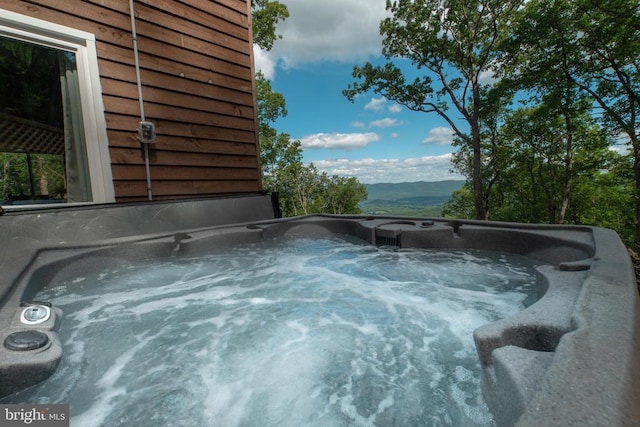 view of pool featuring a mountain view and a hot tub