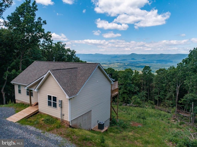 view of side of property with central AC unit and a mountain view