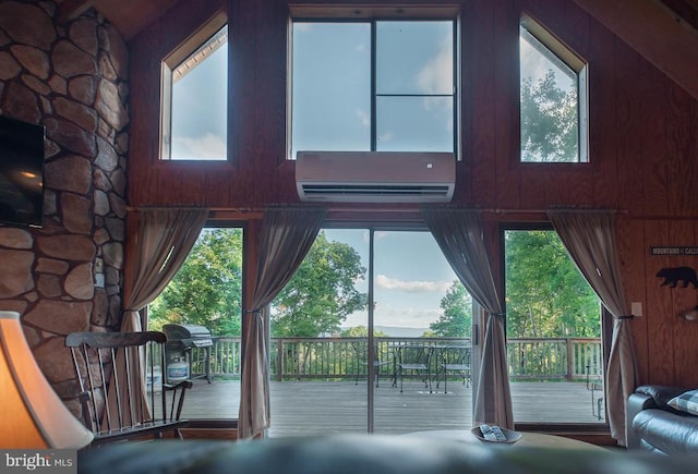 doorway to outside with a wall unit AC, a healthy amount of sunlight, and wood walls