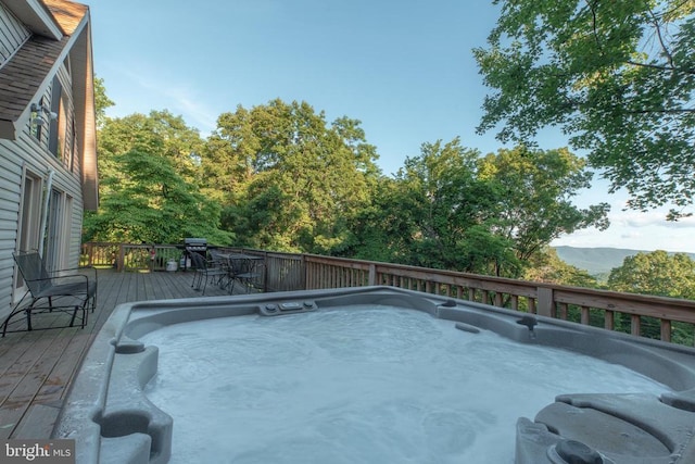 view of pool featuring an outdoor hot tub and a deck with mountain view